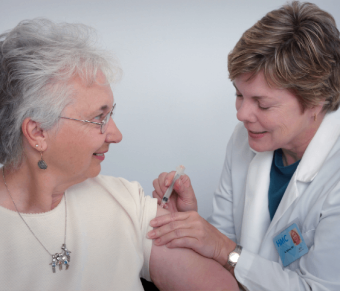 Certified home health aide administering an injection to a patient